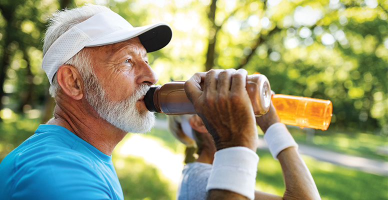 Elderly man drinking from a water bottle after exercise