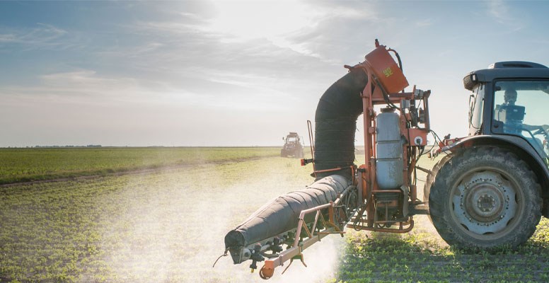 Tractor applying fertilizer to crops